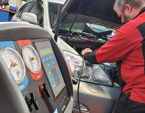 automobile mechanic testing heating and airconditioning systems with diagonostic equipment photo