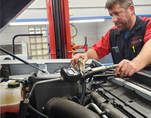 automobile mechanic performing  preventative maintenance on car photo